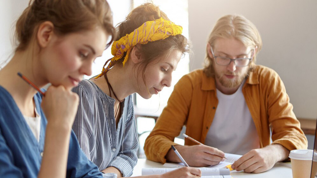 Фото: https://www.freepik.com/free-photo/three-students-sitting-together-their-working-place-writing-with-pencils-studying-scientific-literature-preparing-exams-university-bearded-guy-two-females-working-project_9438050